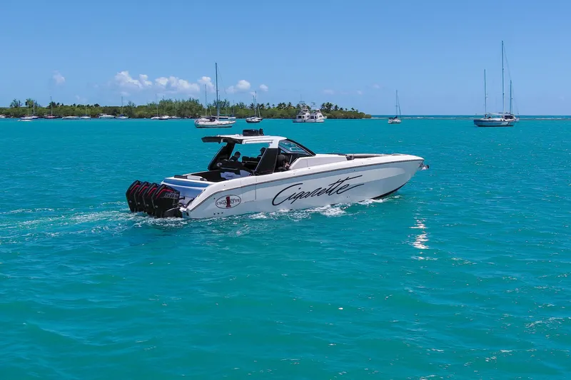  Yacht Photos Pics 2025 Cigarette 42 Auroris boat cruising on turquoise waters with sailboats in the background.