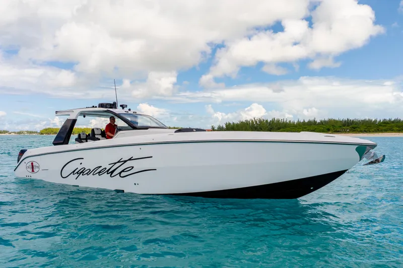  Yacht Photos Pics 2025 Cigarette 42 Auroris boat cruising on clear blue water under a partly cloudy sky.
