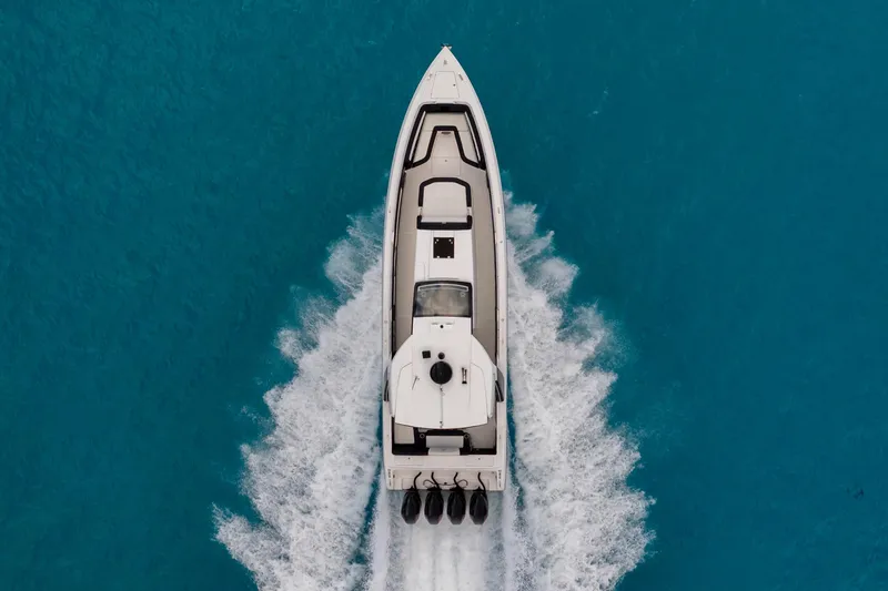  Yacht Photos Pics Aerial view of 2025 Cigarette 42 Auroris speedboat cruising on clear blue water.