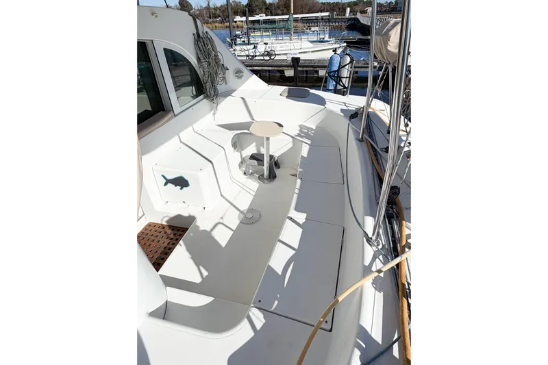 No Ka Oi Yacht Photos Pics 2005 Lagoon 380 S2 yacht deck with seating and small table, docked at marina.