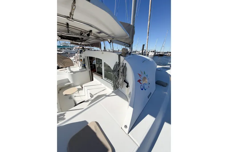 No Ka Oi Yacht Photos Pics 2005 Lagoon 380 S2 catamaran docked at marina, featuring spacious deck and vibrant logo.