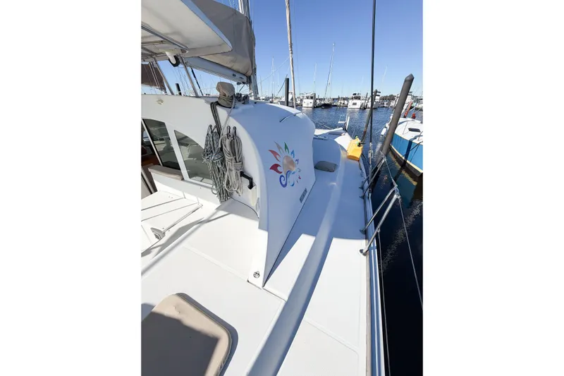 No Ka Oi Yacht Photos Pics 2005 Lagoon 380 S2 catamaran docked at marina, featuring spacious deck and vibrant logo.