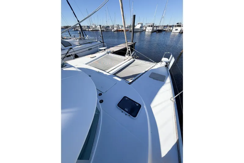 No Ka Oi Yacht Photos Pics 2005 Lagoon 380 S2 catamaran docked at marina, surrounded by sailboats.