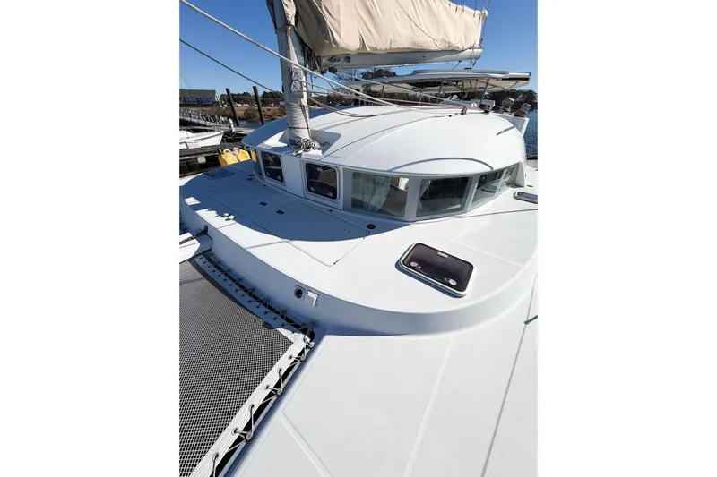 No Ka Oi Yacht Photos Pics 2005 Lagoon 380 S2 catamaran with white deck and sails, docked in a marina.