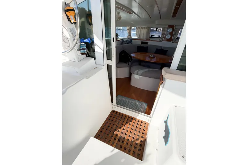 No Ka Oi Yacht Photos Pics Interior view of 2005 Lagoon 380 S2 catamaran, featuring cozy seating and wooden flooring.