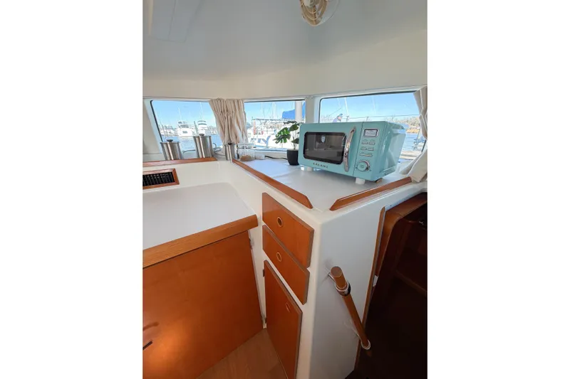 No Ka Oi Yacht Photos Pics Interior of 2005 Lagoon 380 S2 yacht with microwave and wooden cabinetry.