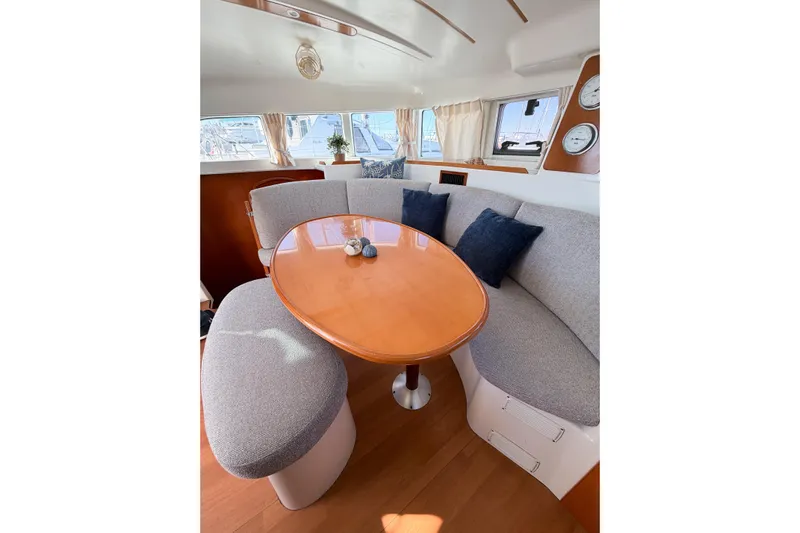 No Ka Oi Yacht Photos Pics Interior of 2005 Lagoon 380 S2 yacht with cozy seating and wooden table.