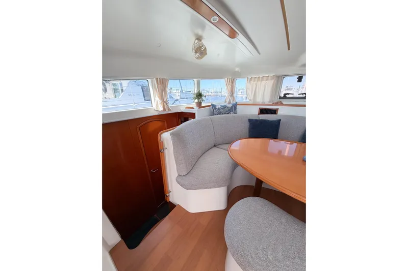 No Ka Oi Yacht Photos Pics Interior of 2005 Lagoon 380 S2 yacht with cozy seating and wooden table.