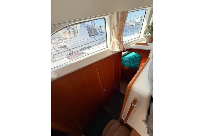 No Ka Oi Yacht Photos Pics Interior view of 2005 Lagoon 380 S2 catamaran, featuring wooden cabinetry and a cozy cabin.