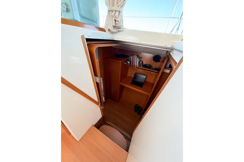 No Ka Oi Yacht Photos Pics Interior view of 2005 Lagoon 380 S2 sailboat cabin with wooden shelves and equipment.