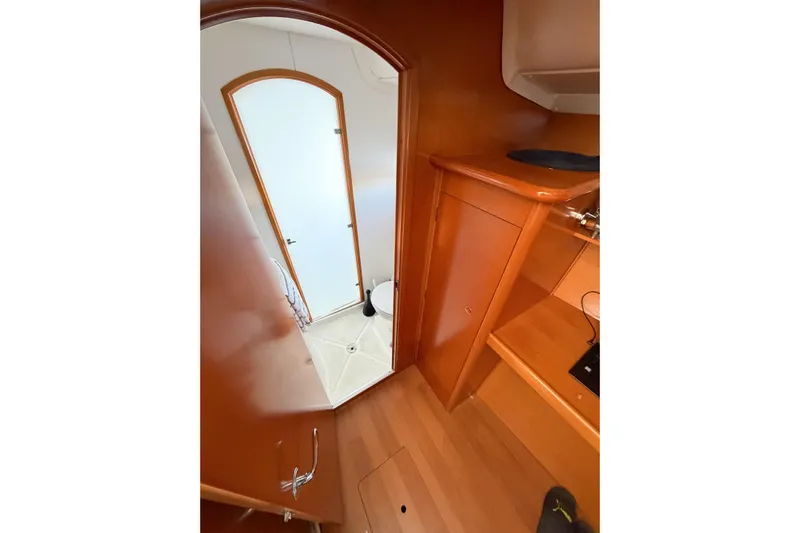 No Ka Oi Yacht Photos Pics Interior view of 2005 Lagoon 380 S2 yacht, featuring wooden cabinetry and a compact bathroom.