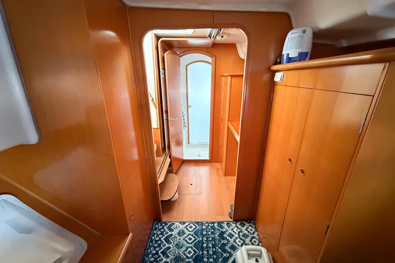 No Ka Oi Yacht Photos Pics Interior of 2005 Lagoon 380 S2 yacht with wooden cabinetry and blue patterned rug.