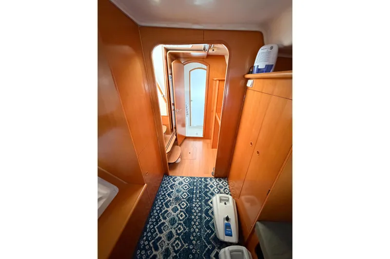 No Ka Oi Yacht Photos Pics Interior of 2005 Lagoon 380 S2 yacht with wooden cabinetry and patterned rug.