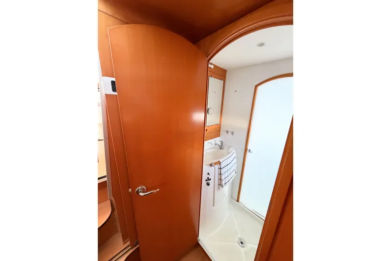 No Ka Oi Yacht Photos Pics Interior of 2005 Lagoon 380 S2 yacht bathroom with wooden door and compact sink.