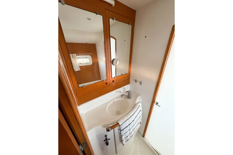 No Ka Oi Yacht Photos Pics Bathroom interior of 2005 Lagoon 380 S2 yacht with sink and mirror.