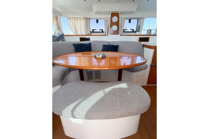 No Ka Oi Yacht Photos Pics Interior of 2005 Lagoon 380 S2 catamaran with cozy seating and wooden table.