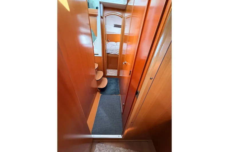 No Ka Oi Yacht Photos Pics Interior hallway of 2005 Lagoon 380 S2 catamaran with wooden finish and cozy cabin view.