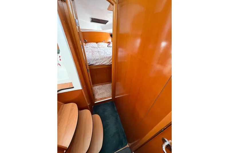 No Ka Oi Yacht Photos Pics Interior view of 2005 Lagoon 380 S2 yacht cabin with wooden finish and cozy bedding.