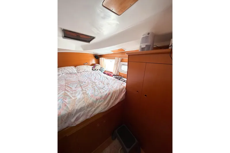 No Ka Oi Yacht Photos Pics Cozy cabin interior of 2005 Lagoon 380 S2 catamaran with bed and storage.