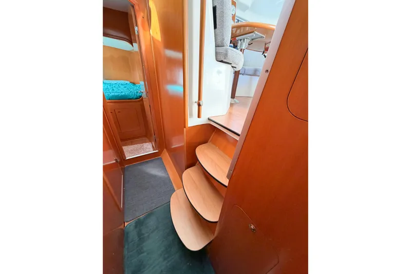 No Ka Oi Yacht Photos Pics Interior of 2005 Lagoon 380 S2 catamaran with wooden steps and cozy cabin.