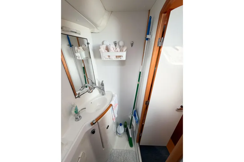 No Ka Oi Yacht Photos Pics Compact bathroom in a 2005 Lagoon 380 S2 yacht with sink and cleaning supplies.