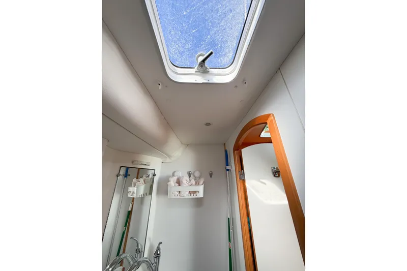 No Ka Oi Yacht Photos Pics Interior of 2005 Lagoon 380 S2 yacht bathroom with skylight and wooden door.