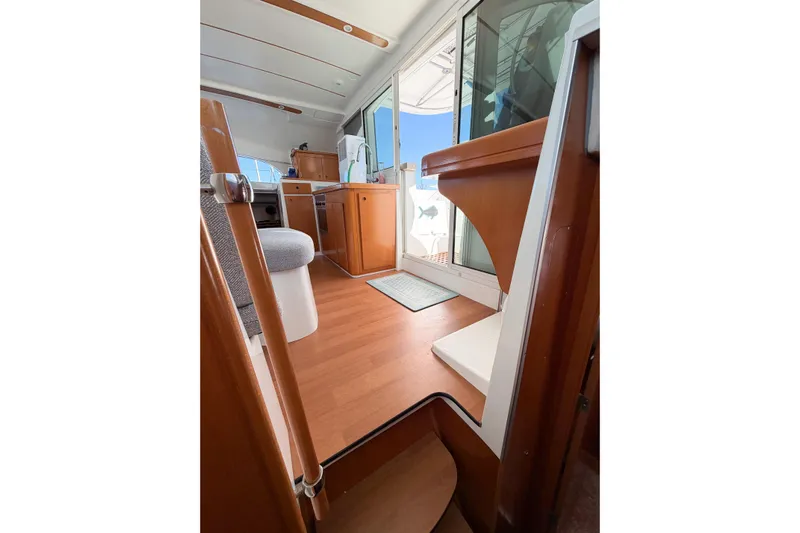 No Ka Oi Yacht Photos Pics Interior view of 2005 Lagoon 380 S2 catamaran, featuring wooden flooring and modern furnishings.
