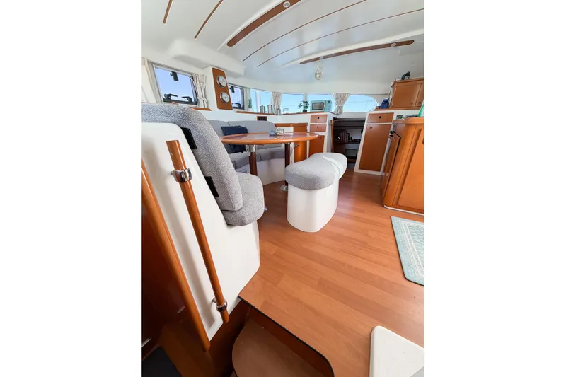 No Ka Oi Yacht Photos Pics Interior of 2005 Lagoon 380 S2 catamaran with wooden flooring and cozy seating area.