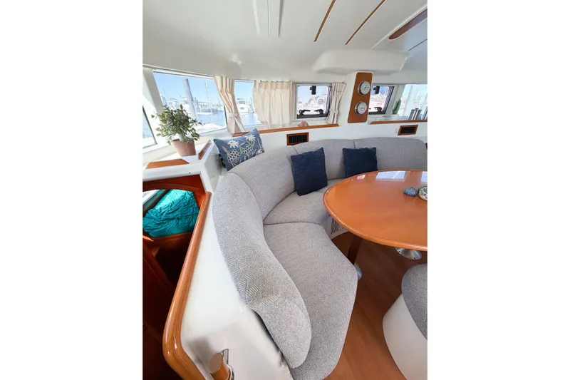 No Ka Oi Yacht Photos Pics Interior of 2005 Lagoon 380 S2 catamaran with cozy seating and round table.