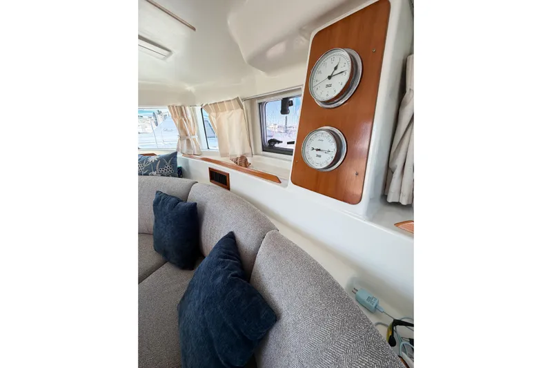 No Ka Oi Yacht Photos Pics Interior of 2005 Lagoon 380 S2 yacht with cozy seating and nautical instruments.