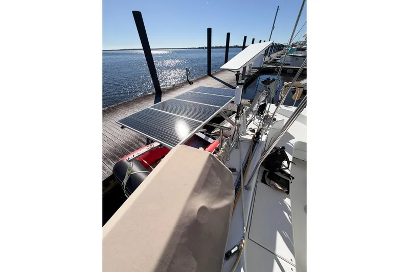 No Ka Oi Yacht Photos Pics 2005 Lagoon 380 S2 catamaran with solar panels docked by the water.