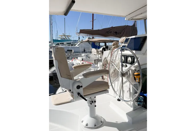 No Ka Oi Yacht Photos Pics Helm station of 2005 Lagoon 380 S2 catamaran with steering wheel and captain's chair.