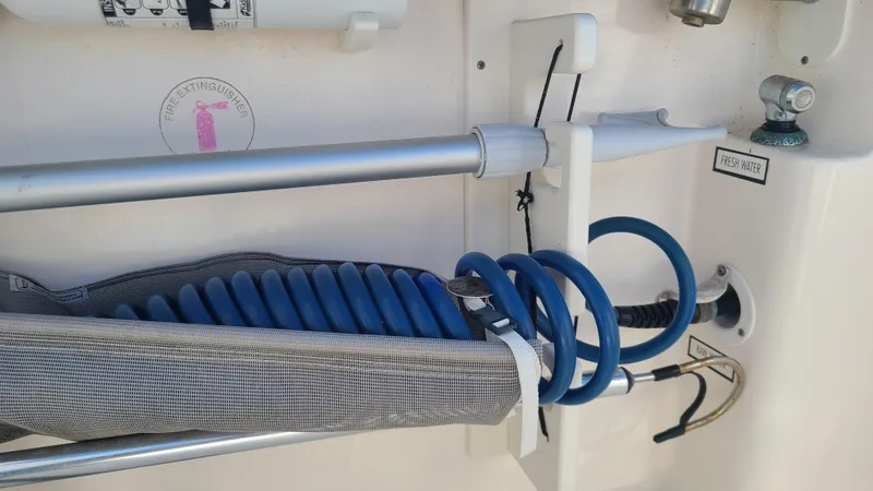  Yacht Photos Pics 2016 Pursuit DC 325 Dual Console boat with coiled blue hose and storage compartment.