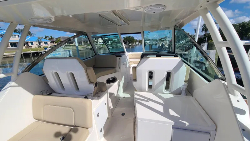  Yacht Photos Pics 2016 Pursuit DC 325 Dual Console boat interior with seating and helm, docked by waterfront homes.