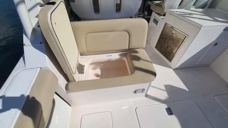  Yacht Photos Pics 2016 Pursuit DC 325 Dual Console boat with open storage compartment under beige seat.