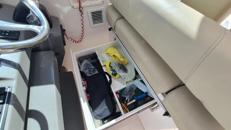  Yacht Photos Pics Storage compartment in 2016 Pursuit DC 325 Dual Console boat, containing various items.