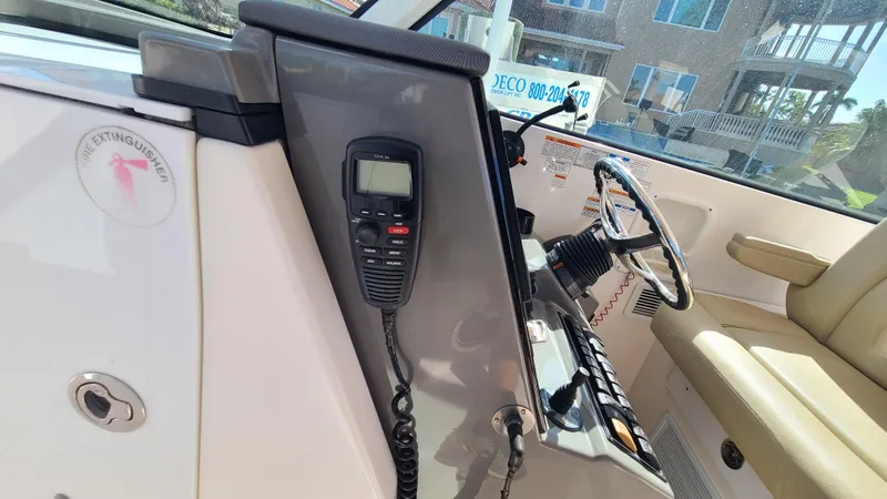  Yacht Photos Pics 2016 Pursuit DC 325 Dual Console boat interior with steering wheel and radio.
