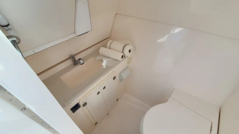  Yacht Photos Pics 2016 Pursuit DC 325 Dual Console boat bathroom with sink, toilet, and storage.