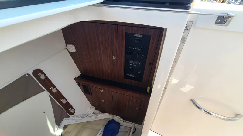  Yacht Photos Pics 2016 Pursuit DC 325 Dual Console interior with wooden panel and storage area.