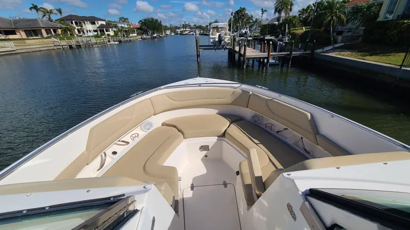  Yacht Photos Pics 2016 Pursuit DC 325 Dual Console boat with spacious seating, docked in a scenic waterfront area.