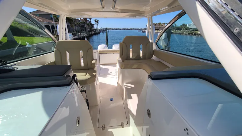  Yacht Photos Pics 2016 Pursuit DC 325 Dual Console boat interior with seating, overlooking a scenic waterfront.