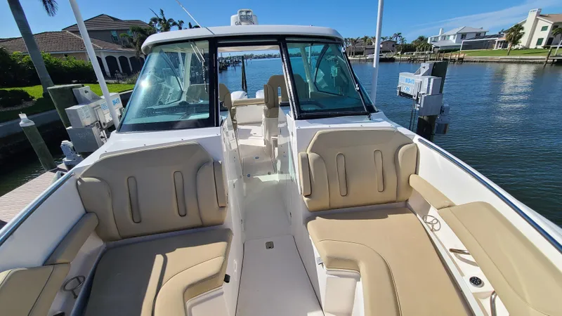  Yacht Photos Pics 2016 Pursuit DC 325 Dual Console boat with spacious seating, docked by waterfront homes.