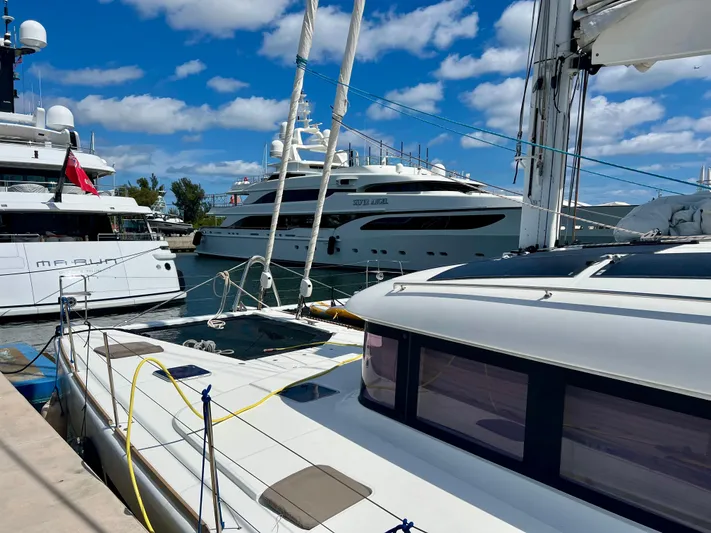  Yacht Photos Pics 2017 Lagoon 620 yacht docked with luxury boats under blue sky.