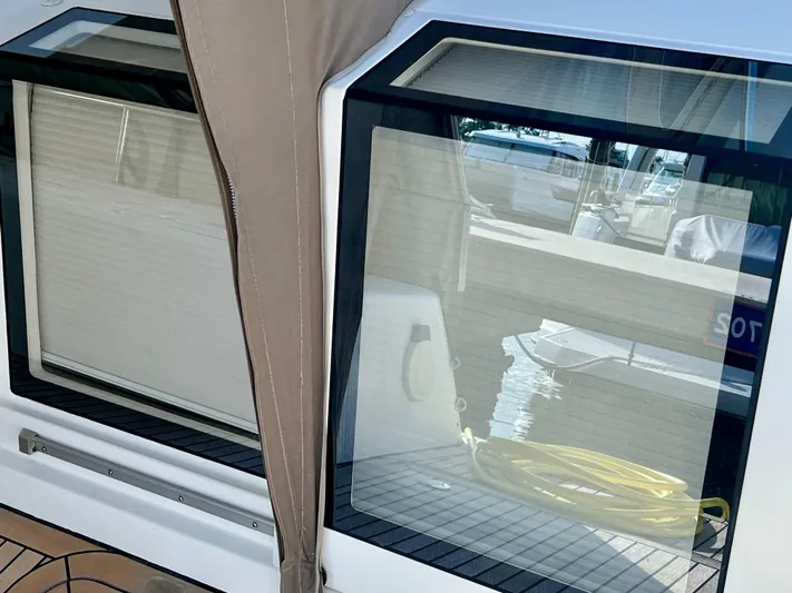  Yacht Photos Pics Lagoon 620 yacht window view, 2017 model, with dock reflection and coiled yellow hose.