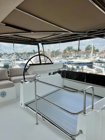  Yacht Photos Pics 2017 Lagoon 620 yacht helm station with seating, docked at marina.