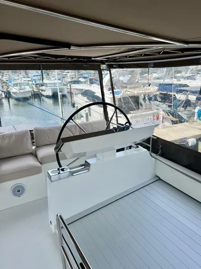  Yacht Photos Pics 2017 Lagoon 620 yacht helm with marina view, featuring modern seating and steering wheel.