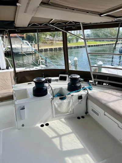  Yacht Photos Pics 2017 Lagoon 620 yacht cockpit with winches and seating, docked by the water.