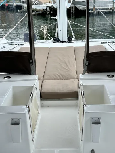  Yacht Photos Pics 2017 Lagoon 620 yacht interior with beige seating and storage compartments, docked at a marina.