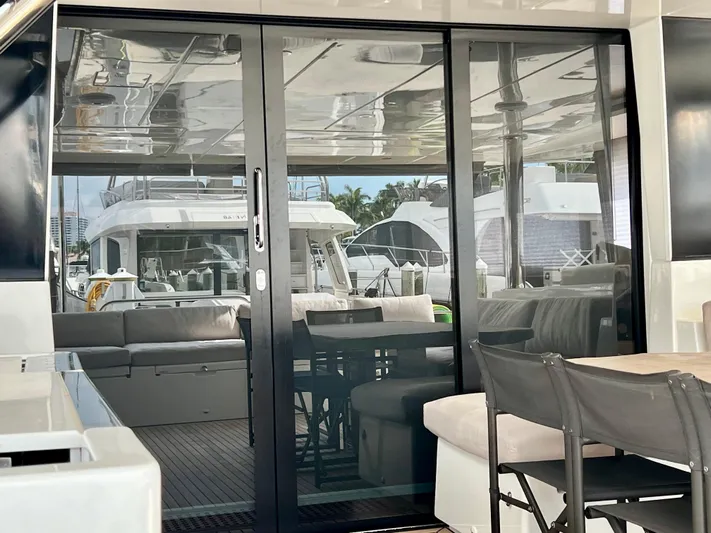  Yacht Photos Pics Luxurious Lagoon 620 yacht interior with glass doors, showcasing modern seating and elegant design, 2017 model.