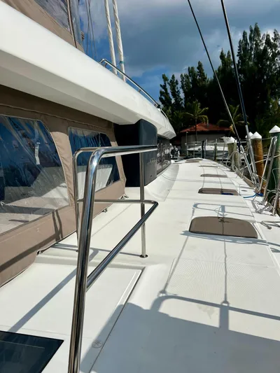  Yacht Photos Pics 2017 Lagoon 620 yacht deck with sleek design and modern features, docked under a cloudy sky.